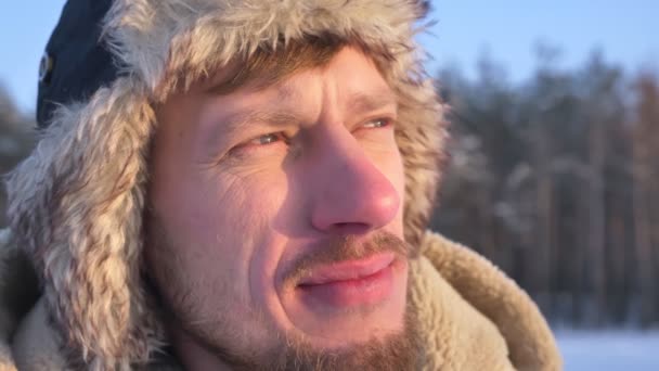 Close-up shot of middle-aged explorer in hood and coat watching at sun joyfully. — Stock Video