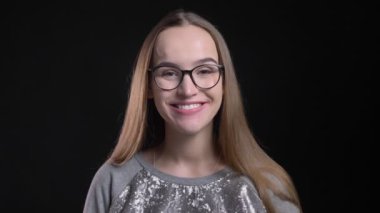 Portre genç çekici hipster kameraya düz seyir ve mutlu bir şekilde izole siyah arka plan ile gülümseyen gözlüklü kadın ateş