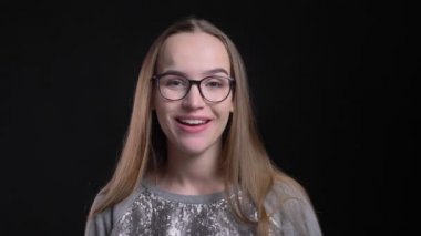 Bir dil gösterilen ve arka plan üzerinde siyah izole doğruca kameraya bakarak aptal oynarken gözlüklü genç çekici hipster erkek portre çekimleri