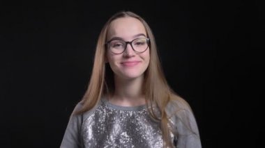 Portre genç çekici hipster gülümseyen ve arka plan üzerinde siyah izole doğruca kameraya bakarak Merhaba sallayarak gözlüklü kadın ateş