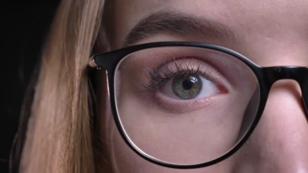 Closeup poloobličejových natáčení mladé atraktivní bokovky ženské tváře v brýlích a s očima díval přímo na kameru