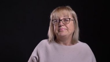 Üst düzey Beyaz sarışın kadın gözlük frustraterd olmak ve arka plan üzerinde siyah izole kamera önünde tatminsiz portre çekimi