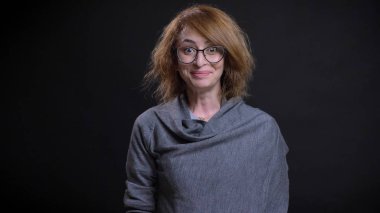 Heyecan ve mutluluk ile doğrudan kameraya bakarken gülümseyen bardakları orta yaşlı abartılı Kızıl saçlı kadın portresi portre