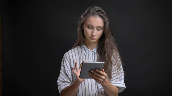 Nahaufnahme einer jungen hübschen kaukasischen Frau beim SMS-Schreiben auf dem Tablet vor der Kamera mit isoliertem Hintergrund — Stockfoto