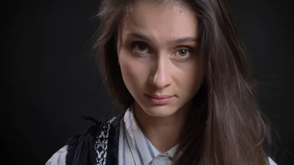 Primer plano retrato de joven linda cara femenina caucásica con ojos marrones y cabello moreno mirando directamente a la cámara con un fondo aislado — Foto de Stock