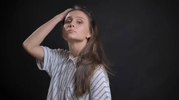 Primeros planos de joven atractiva modelo de moda femenina caucásica lanzando el pelo y posando frente a la cámara con confianza mirando directamente —  Fotos de Stock