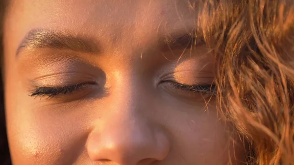 Close-up eye-portrait of pretty curly-haired caucasian girl with closed eyes.