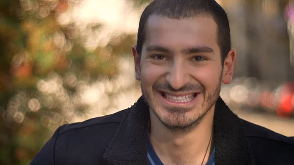 Porträt eines kaukasischen Mannes, der glücklich in die Kamera auf der Straße lächelt. — Stockfoto