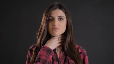 Plaided gömlek siyah arka plan üzerine korkunç boğaz acı genç güzel uzun saçlı kız portresi.