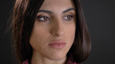 Yakın çekim plaided gömlek cidden sola doğru siyah arka plan üzerine izlerken genç güzel uzun saçlı kız portresi.