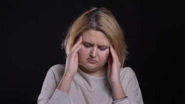 Sarışın kısa saçlı kilolu iş kadın yapma masaj siyah arka plan üzerine baş ağrısı.