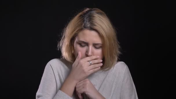 Blonde short-haired overweight businesswoman suffering from sore throat and coughing on black background. — Stock Video