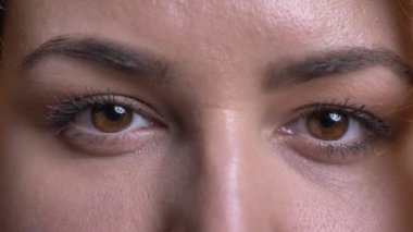 Yakın çekim göz-orta yaşlı kilolu kadın portresi kameraya sakince ve mütevazi siyah arka plan üzerine saatler.