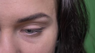 Yakın çekim yarı-portresi genç esmer işkadını ciddi ve mütevazi kameraya saatler.