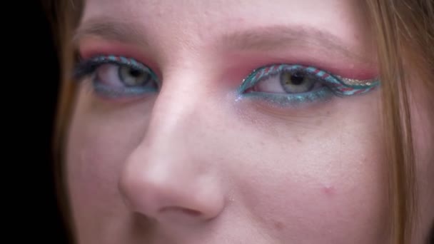 Close-up oog schot van blonde model met lichte make-up langzaam verandert gezicht om aan te tonen van de schoonheid op de achtergrond wazig lights. — Stockvideo