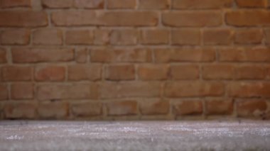 Yakın çekim shot bricken duvar arka plan üzerinde tüylü bir halı üzerinde ileriye tiptoeing kırılgan kadın bacakları.