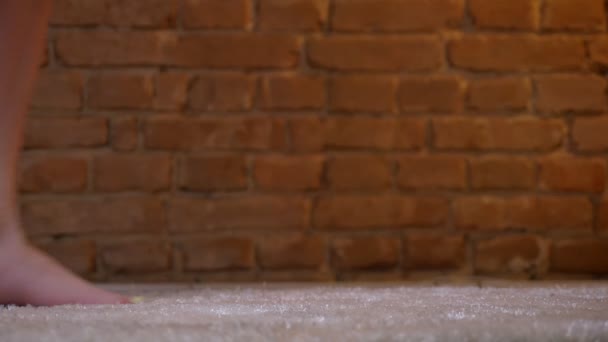 여성 다리 춤을 만들기의 근접 샷 bricken 벽 배경에 모피 카펫에 앞으로 단계. — 비디오
