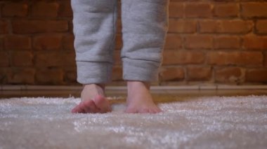 Kadın çıplak bacaklar ve tüylü bir halı bricken duvar arka plan üzerinde birbiri ardına devam çoraplı erkek olanlar yakın çekim shot.