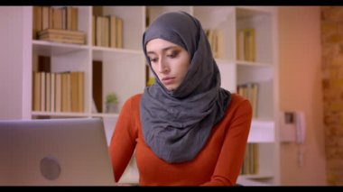 Closeup çekim genç çekici Müslüman kadın çalışanın ofis kapalı içinde belgili tanımlık laptop yazarak Türban