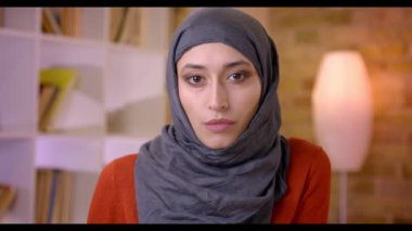 Closeup çekim genç çekici Müslüman kadın çalışanın ofis kapalı işyerinde kameraya bakarak