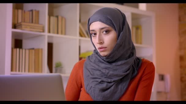 Крупним планом знімок молодого привабливого мусульманського працівника, який друкує на ноутбуці, є успішним і щасливо посміхається в приміщенні в офісі — стокове відео