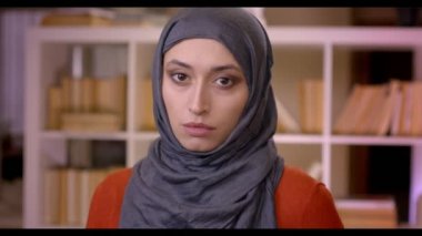 Closeup çekim genç çekici Müslüman kadın öğrencilerin kütüphanede kapalı kamera ayakta bakarak Türban