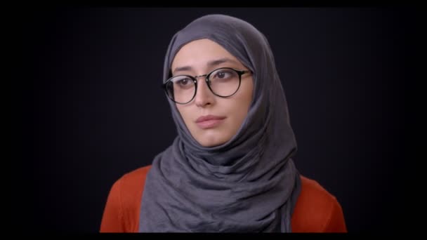 Primo piano sparare di giovane femmina musulmana attraente in hijab con sfondo isolato su nero — Video Stock