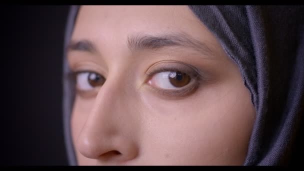Closeup προφίλ σουτ του νέους ελκυστικές μουσουλμανική γυναικείο πρόσωπο στο χιτζάμπ βλέπουν φωτογραφική μηχανή με απομονωμένα σε μαύρο φόντο — Αρχείο Βίντεο