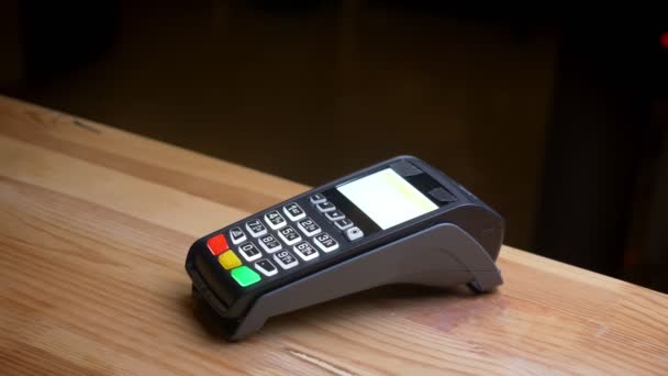 Tiro de perto de um terminal de pagamento que está sendo usado para pagamento por um aplicativo no telefone no local de trabalho do escritório dentro de casa — Vídeo de Stock