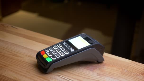 Sesión de primer plano de una terminal de pago que se utiliza para el pago por una aplicación en el teléfono con el pago que se verifica en el lugar de trabajo de la oficina en interiores — Vídeos de Stock