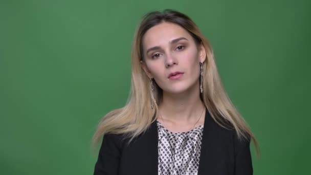 Close-up schieten van jonge aantrekkelijke hipster Kaukasische vrouw op zoek rechtdoor en poseren in de voorkant van de camera met achtergrond geïsoleerd op groen — Stockvideo