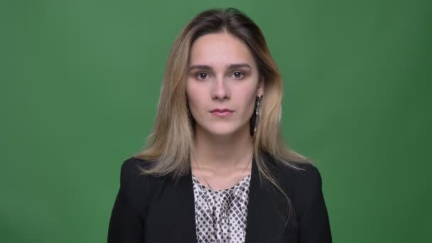 Closeup shoot of young attractive hipster caucasian female looking straight at camera with background isolated on green — Stock Video