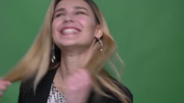 Genç çekici hipster beyaz kadın onun saç arka planda yeşil üzerinde izole ile mutlu gülüyor çırpınan ile dönüm çekim çekim