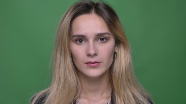 Nahaufnahme einer jungen attraktiven kaukasischen Hipster-Frau, die süß und fröhlich lächelnd ist, während sie direkt in die Kamera schaut, mit einem auf Grün isolierten Hintergrund — Stockvideo