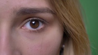 Genç çekici hipster beyaz kadın yüz çekim yarım yüz çekim yeşil üzerinde izole arka plan ile kamera düz görünümlü