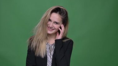 Genç çekici hipster beyaz kadın utangaç ve sevimli gülümseyen mutlu arka planda yeşil üzerinde izole kamera ile düz görünümlü çekim