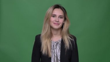 Genç çekici hipster beyaz kadın utanç verici çekim ve yeşil üzerinde izole arka plan ile beceriksizlik ile kamera düz bakıyor