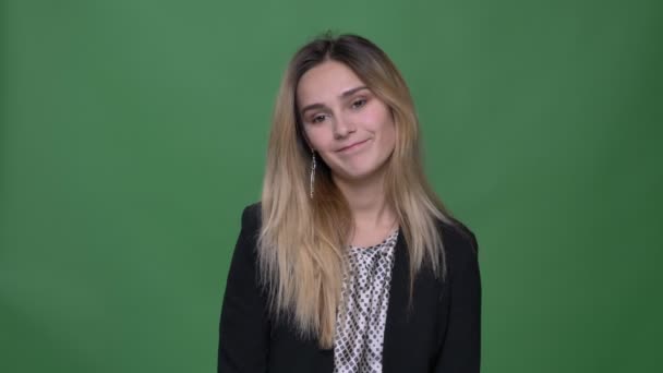 Closeup shoot of young attractive hipster caucasian female being embarrassed and confused looking straight at camera with background isolated on green — Stock Video