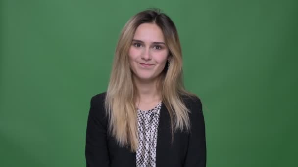 Closeup shoot of young attractive hipster caucasian female being puzzled and confused looking straight at camera with background isolated on green — Stock Video