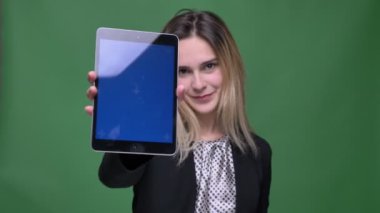 Tablet kullanarak genç çekici hipster beyaz kadın closeup çekim ve yeşil üzerinde izole arka plan ile mutlu bir fotoğraf makinesi mavi Chroma ekran gösteren