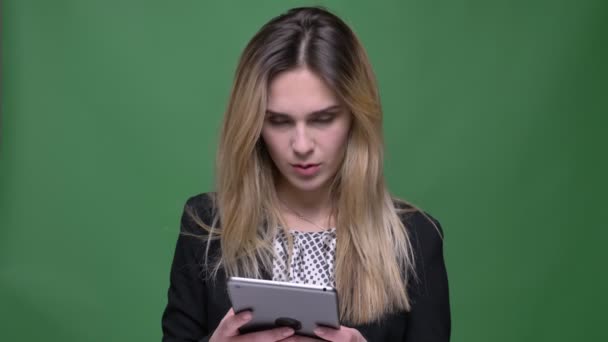 Primo piano di ripresa di giovane attraente hipster femmina caucasica utilizzando il tablet e guardando la fotocamera con sfondo isolato su verde — Video Stock