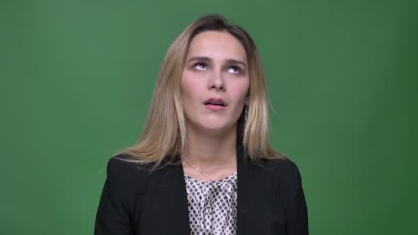 Closeup shoot of young attractive hipster caucasian female being irritated and making an eye roll clapping her head with a hand in front of the camera with background isolated on green — Stock Video