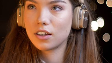 Genç çekici beyaz kadın müzik kulaklık dinlemek ve bokeh ile rüya portre portre arka plan üzerinde ışıklar