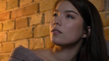 Portre genç sevimli beyaz esmer düşünceli ve fantasizing rahat evde kapalı olmak kadın ateş