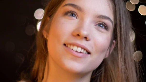 Closeup retrato de jovem muito caucasiano feminino com cabelo morena sorrindo com sonhando expressão facial com fundo bokeh — Fotografia de Stock