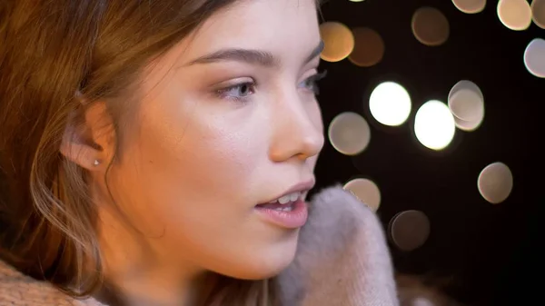 Nahaufnahme Shooting der jungen attraktiven brünetten kaukasischen Frau mit Bokeh-Lichter auf dem Hintergrund Stockbild