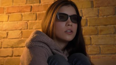 Genç sevimli beyaz kadın yüzü bir korku filmi 3d TV şok gözlük ve geniş açık gözlere sahip korkuttu izlerken closeup portresi