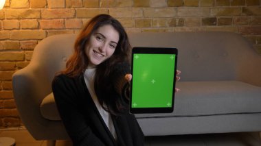 Tablet üzerinde tarama ve yeşil renk ekran kamera için hoş bir ev kapalı gösterilen genç oldukça beyaz kadın portresi portre
