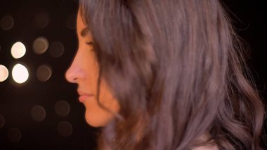 Portre yan görüntülemek genç çekici beyaz kadın yüzü bokeh ışıkları ile arka plan üzerinde gözle ateş