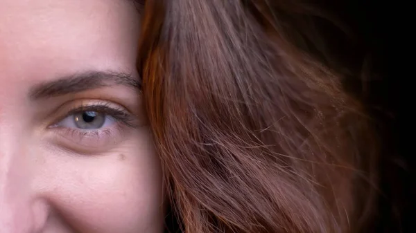 Close-up meia-face atirar de jovem atraente rosto feminino caucasiano olhando diretamente para a câmera com luzes bokeh no fundo — Fotografia de Stock